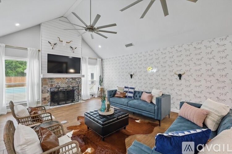 A living room with a blue couch and a fireplace.