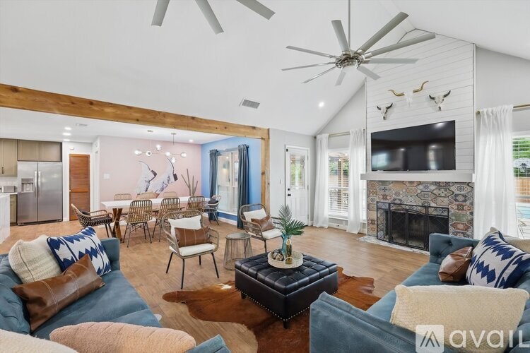 A living room with a blue couch and a fireplace.