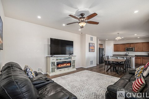 A living room with a black leather couch and a television.