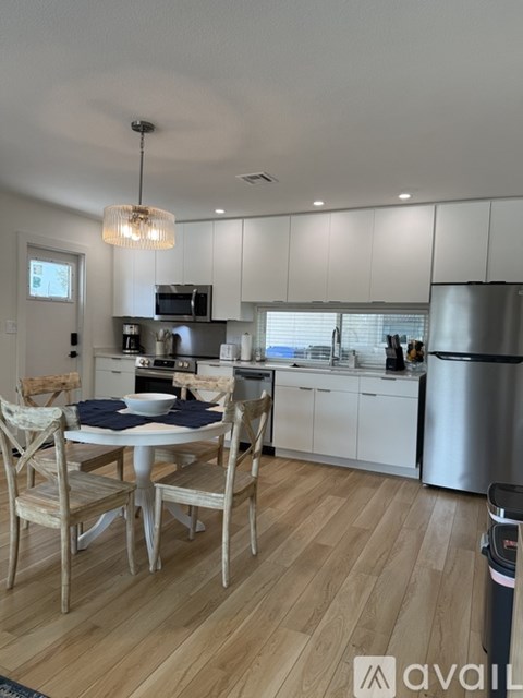 A kitchen with a table and chairs in the middle of the room.