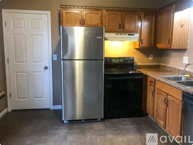 A kitchen with white appliances and a grey wall.