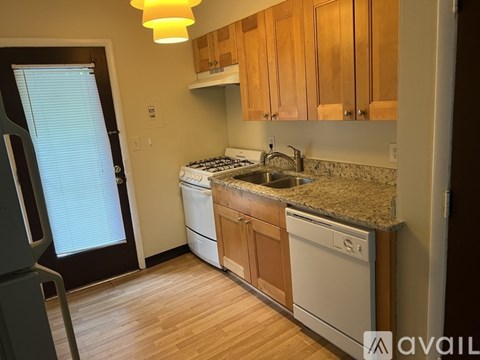 A kitchen with wooden cabinets and a granite countertop.