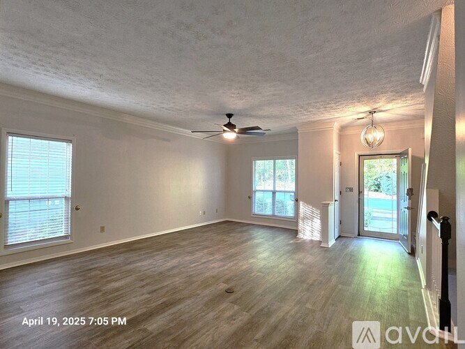 A room with wooden flooring and a ceiling fan.