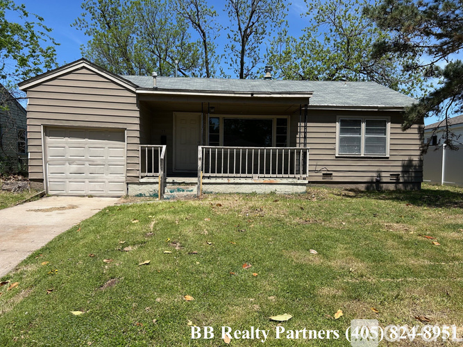 A house with a garage and a porch is for sale.