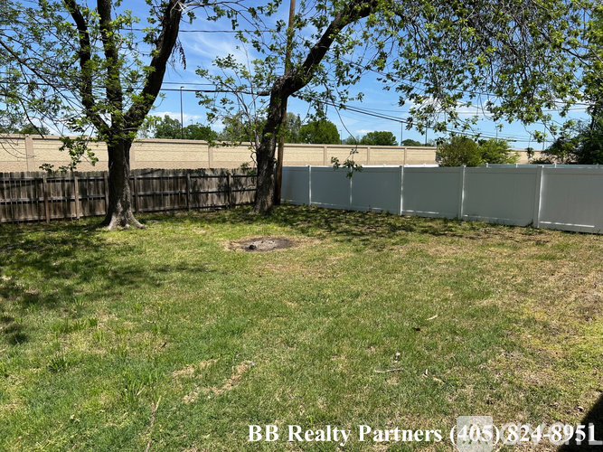 A backyard with a fence and trees.