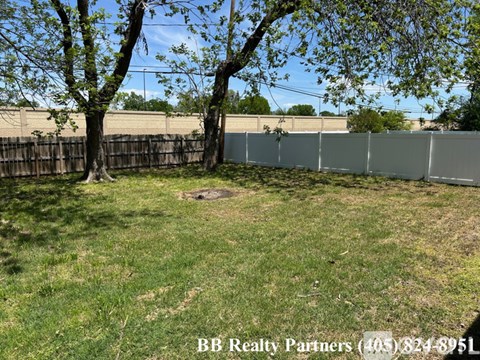 A backyard with a fence and trees.