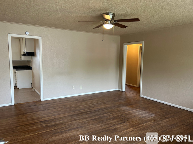 A room with a ceiling fan and wooden flooring is on the market with BB Realty Partners.