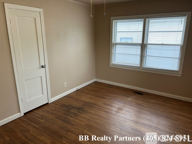 A room with a door and a window with blinds.