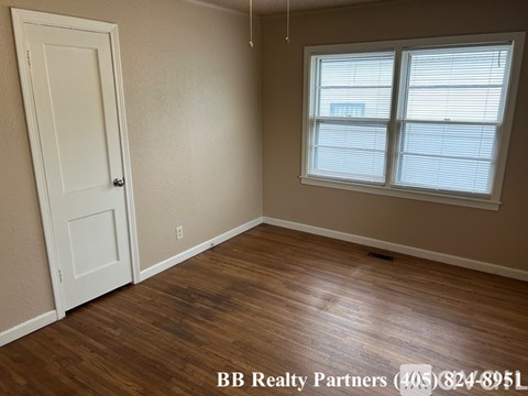 A room with a door and a window with blinds.