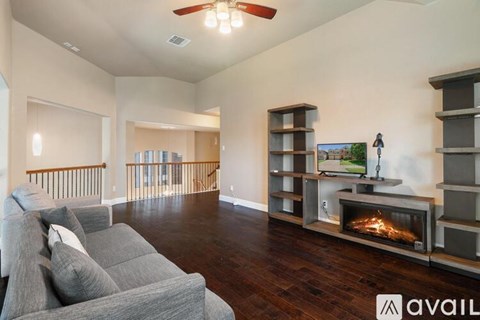 A living room with a grey couch and a fireplace.