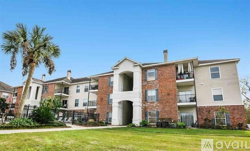 A large apartment complex with a palm tree in front.