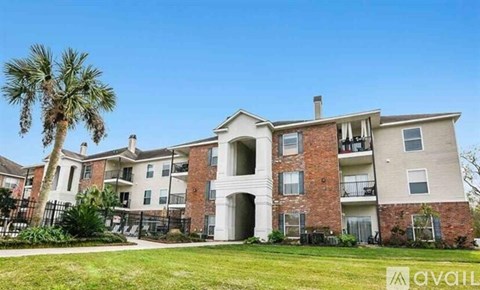 A large apartment complex with a palm tree in front.