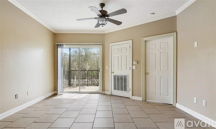 A room with a ceiling fan and tile flooring.