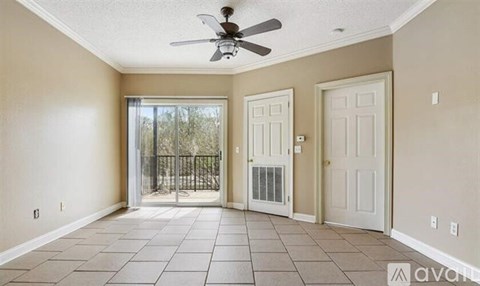 A room with a ceiling fan and tile flooring.