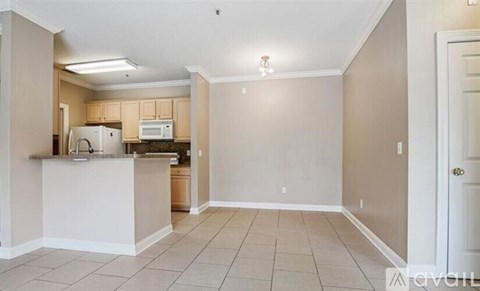 A kitchen area with a refrigerator, microwave, and sink.