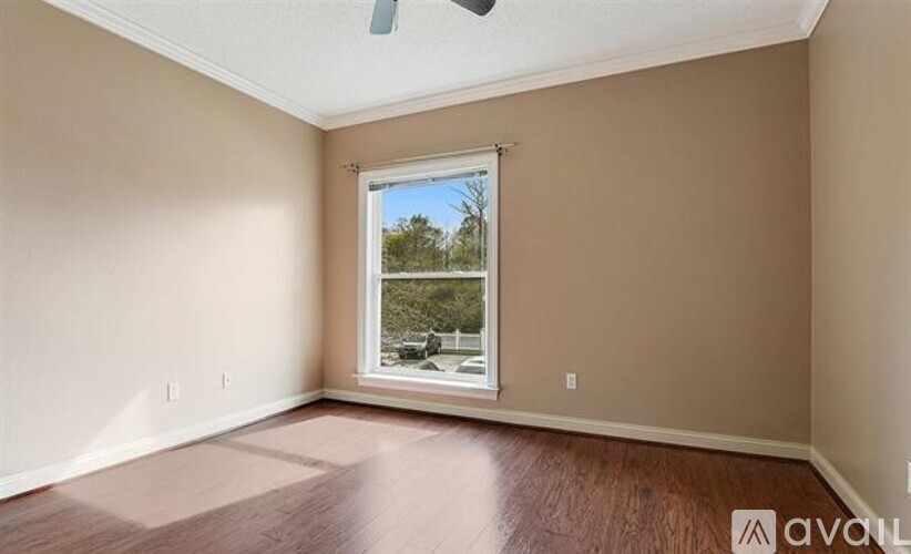 A room with a window overlooking a green area.