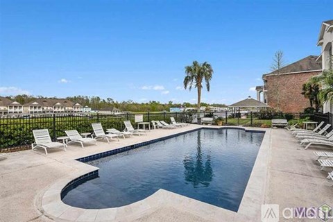 A large outdoor swimming pool surrounded by lounge chairs.