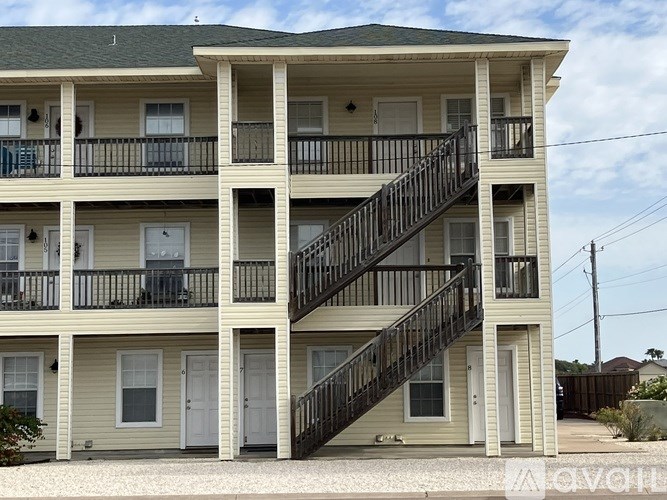 A two-story apartment building with a balcony on the second floor.
