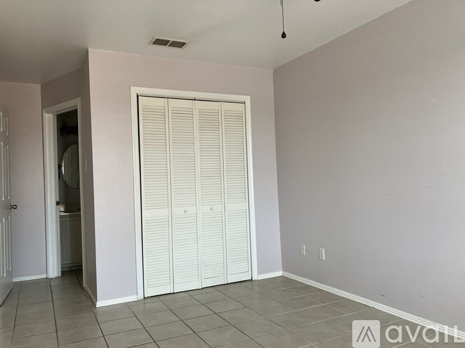 A room with a white door and a tiled floor.