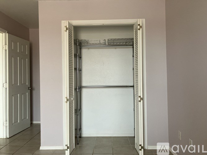 A white door with a metal grate in the middle is open.