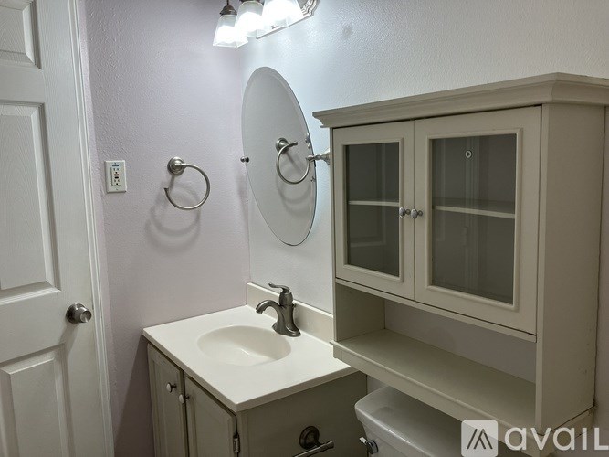 A bathroom with a sink, mirror, and medicine cabinet.
