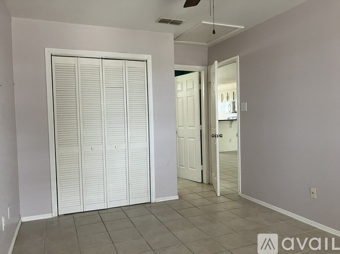 A room with a white door and a white closet with a sign that says "AVAIL".