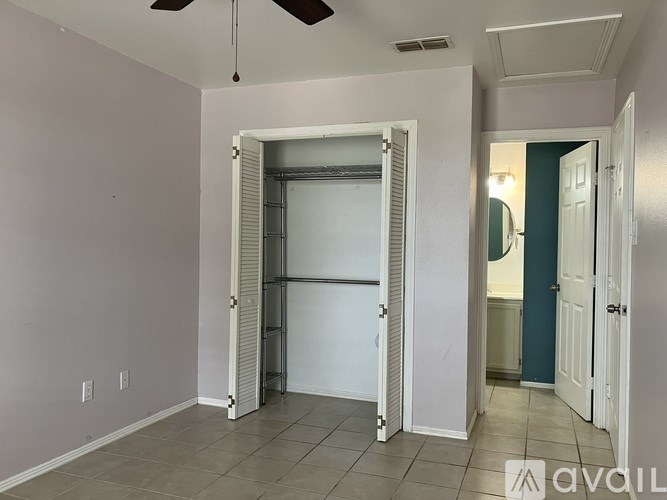 A room with a white door and a fan on the ceiling.