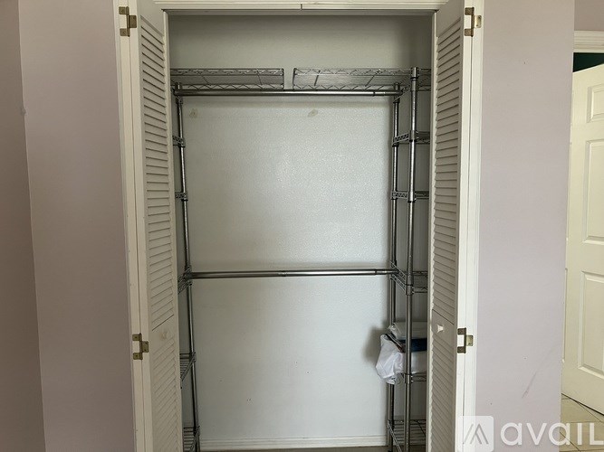 A white door with a metal shelf on the left side.