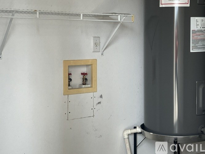 A picture frame with two bottles is hanging on a wall.