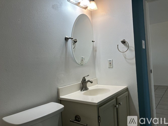 A bathroom with a white sink and a white toilet.