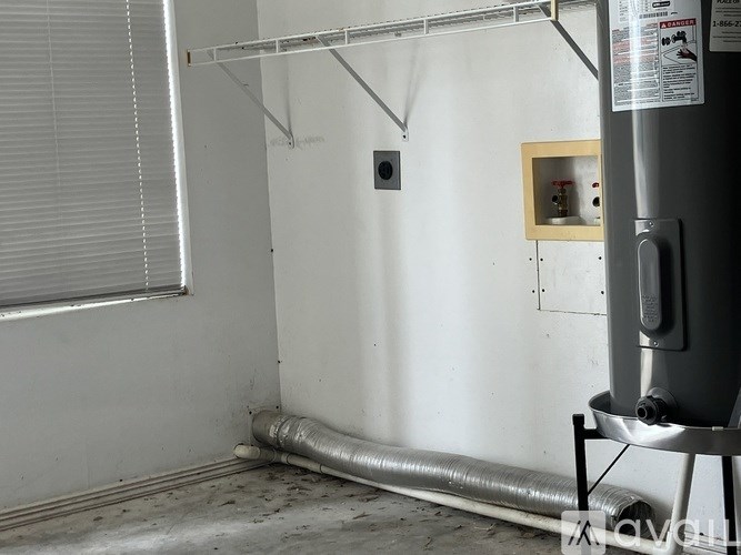A room with a white wall and a metal pipe running along the floor.