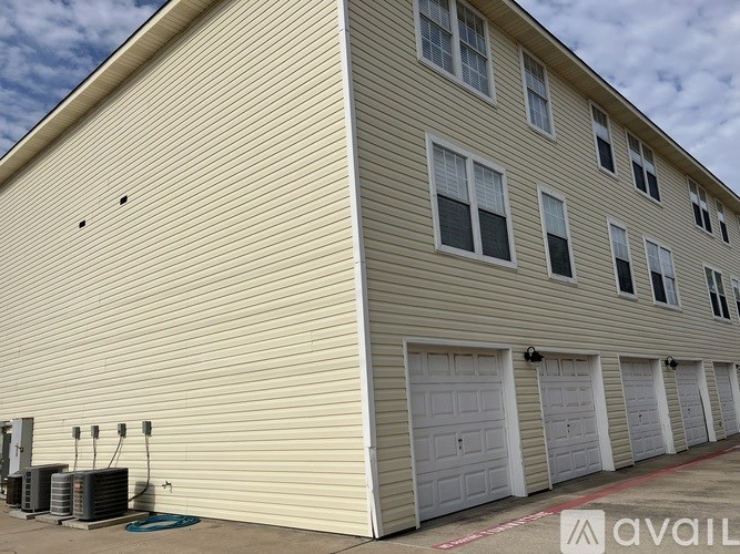 A building with a beige exterior and white garage doors.