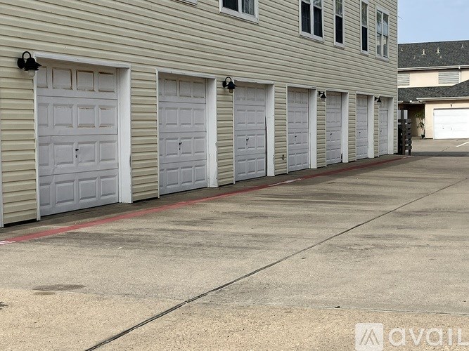 A row of white garage doors are closed.