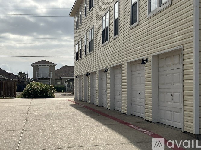 A row of garage doors in front of a building with a sign that says "available".