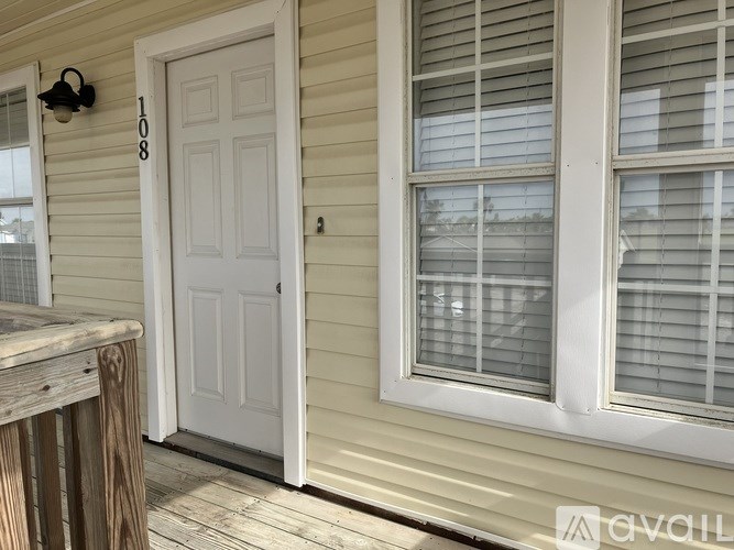 A white door with a number 108 on the wall above it.