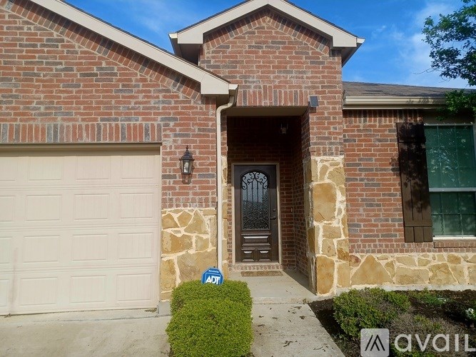 A house with a white garage door and a brown door with a window above it.