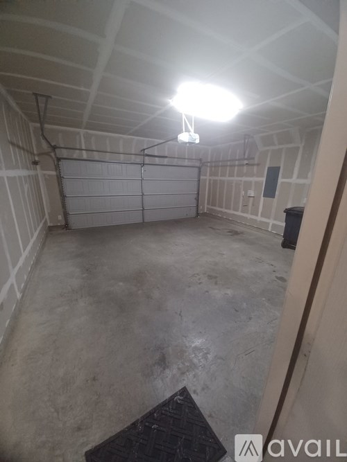 A spacious garage with a single light on.