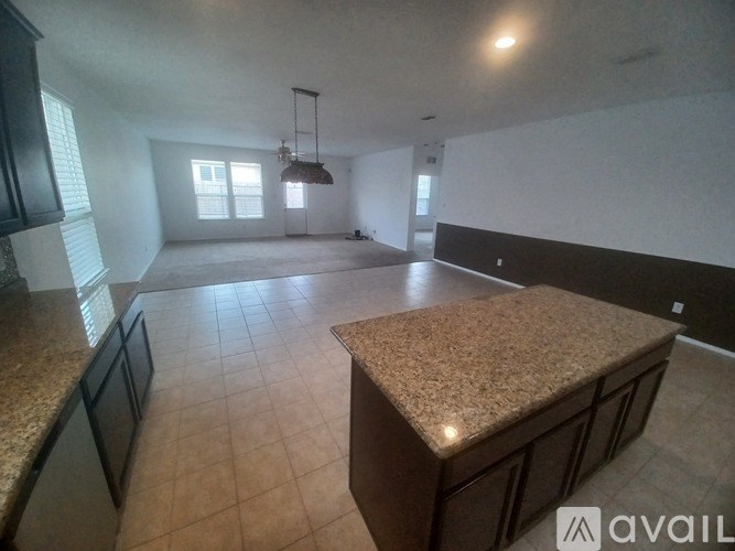A kitchen with granite countertops and black cabinets.