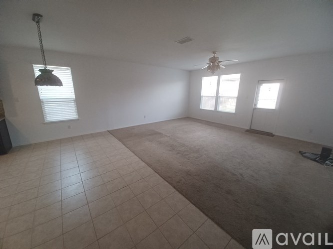 A room with a ceiling fan and two windows.