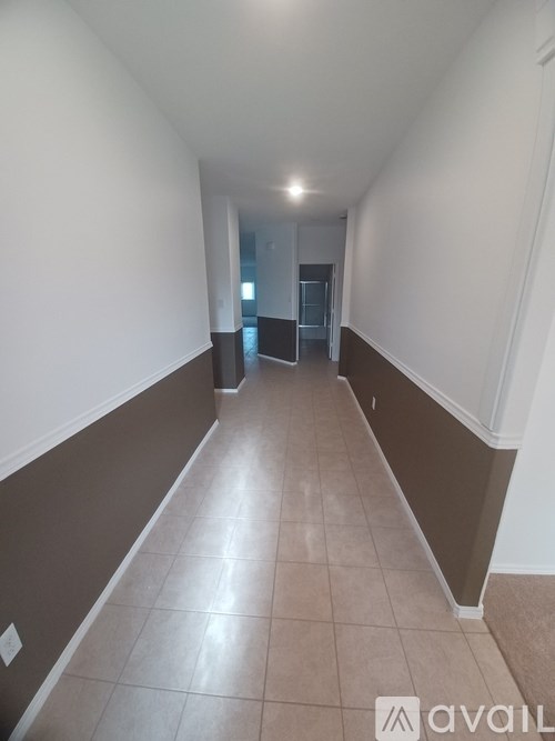A long hallway with a carpeted floor and white walls.