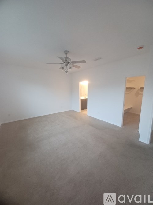 A room with a ceiling fan and a light on.