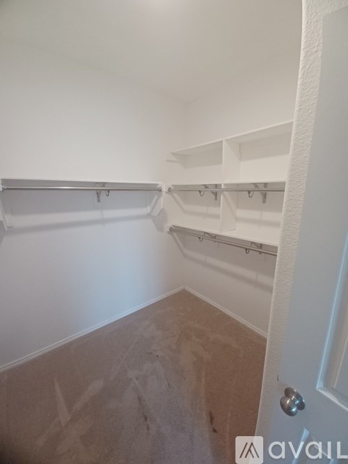 A room with white walls and a door on the right side.