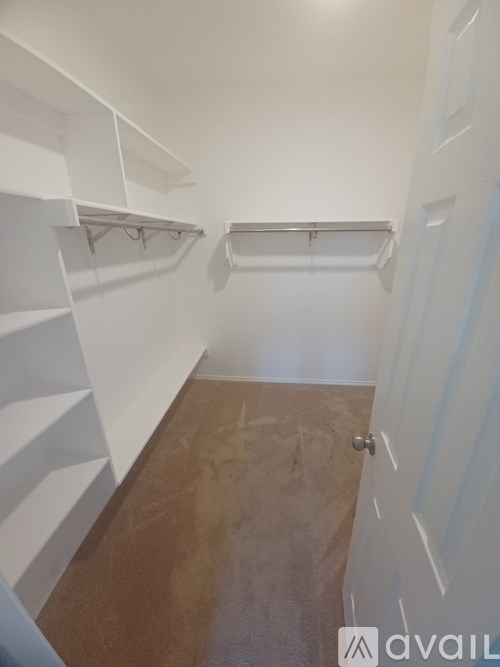 A hallway with white walls and a wooden floor.