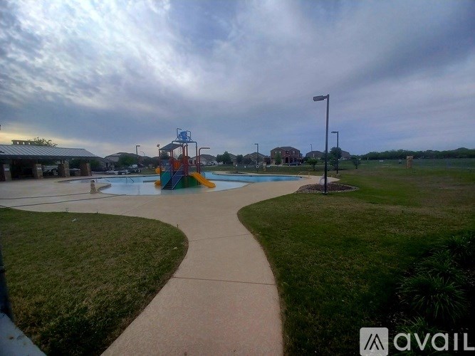 A playground with a slide and a walkway leading to it.