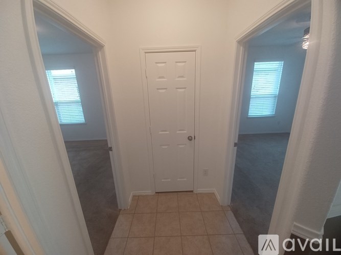 A white door is in the middle of a hallway.
