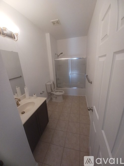 A bathroom with a toilet, sink, and shower.
