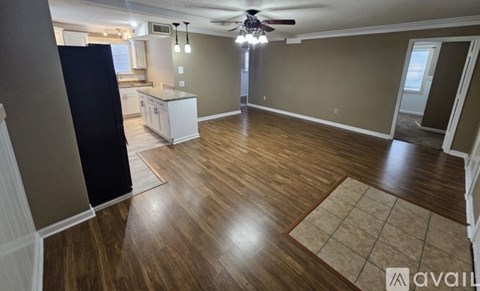 A kitchen with a stove, sink, and cabinets.