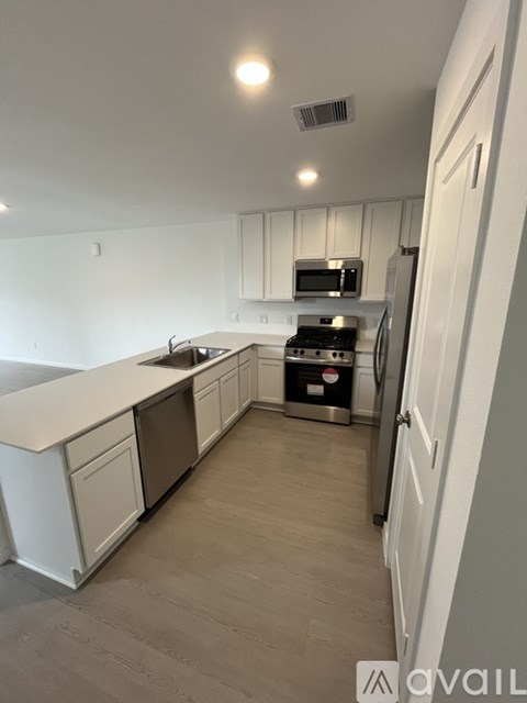 A kitchen with white cabinets and a white counter top.