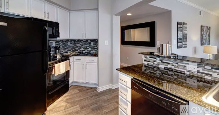 A kitchen with a black refrigerator and a black dishwasher.