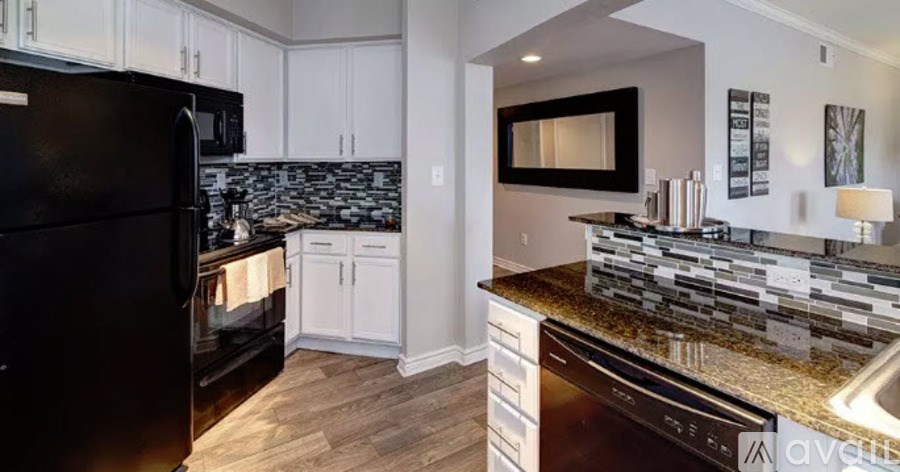 A kitchen with a black refrigerator and a black dishwasher.
